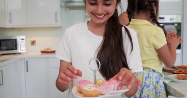 Framsida Liten Flicka Som Sortering Genom Cupcakes Cake Stand Stående — Stockvideo