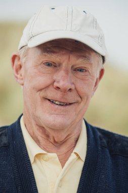 Yaşlı adam sahilde gülümseyen