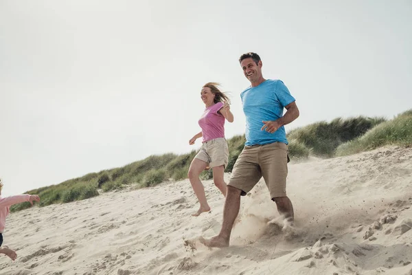 Пара, бегущая по песчаной дюне — стоковое фото