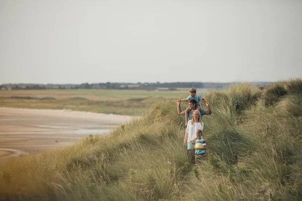 Famiglia che cammina attraverso le dune di sabbia — Foto Stock