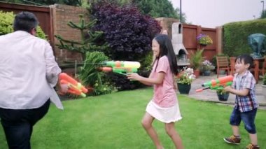 Dört Kişilik Aile bir su yaşıyorsanız su tabanca ile bahçesinde kavga.