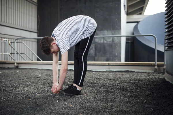 Freerunner dehnt sich auf einem Dach — Stockfoto