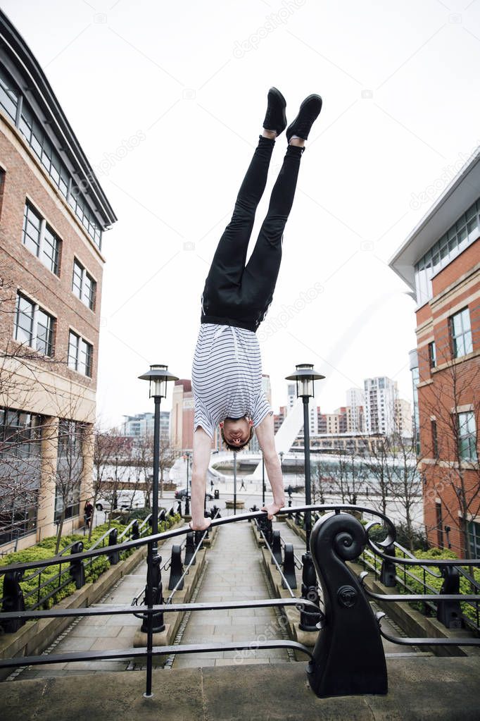 Freerunner Doing a Handstand in the City