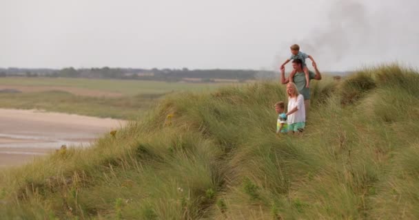 ワイド アングル スローモーション ノーサンバーランドで休暇中に砂丘を歩く家族の — ストック動画