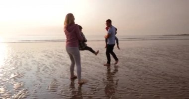 Ağır çekim bir aile eğleniyor ve anılar tatildeyken plajda yapma. Anne oğlu, gülen ve şaka dönüyor.