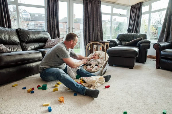 Vader ontspannend thuis met zijn Baby dochter — Stockfoto