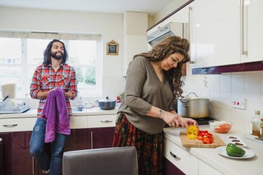 Yetişkin adam mutfakta Ocak tarihinde bir köri hazırlanırken, annesine konuşmak rahatlatıcı. 