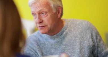 Yetişkin bir adamın bir kafede arkadaşlarıyla konuştuğu yakın plan bir fotoğraf..