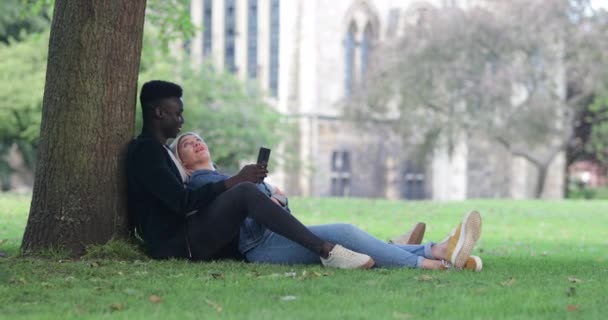 Ein Mann Und Eine Frau Sitzen Einem Park Gegen Einen — Stockvideo