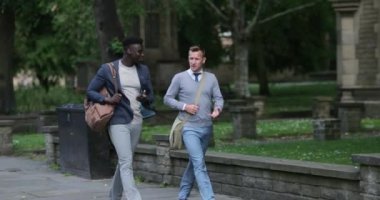 İki işadamı şehirde birlikte yürüyorlar..