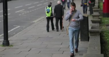 İş adamı telefonda konuşurken ve saati kontrol ederken işe gidiyormuş..