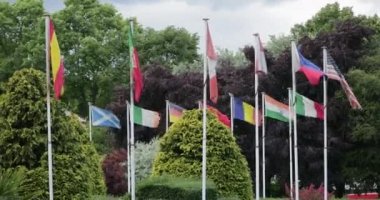 Dünyanın dört bir yanından bayrak direkleri, rüzgarda dalgalanan.