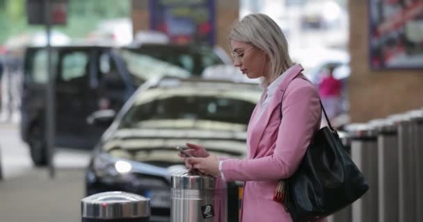 Uma Mulher Negócios Olhar Para Telemóvel Enquanto Estava Numa Banca — Vídeo de Stock