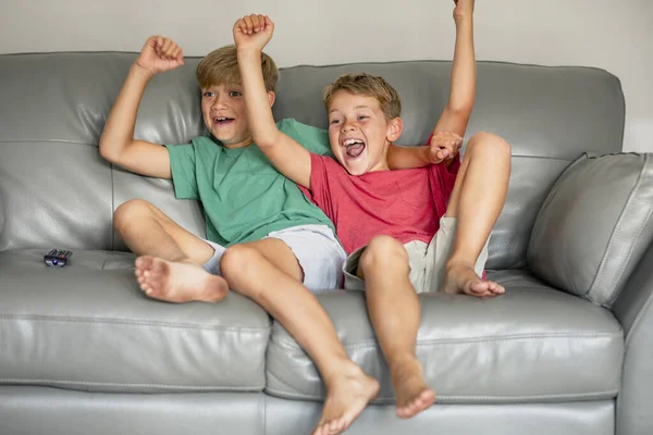 Tiro Dois Irmãos Jovens Sentados Sofá Juntos Assistindo Eles Estão — Fotografia de Stock