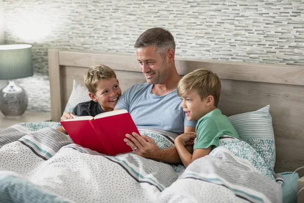 Disparo Padre Leyendo Libro Sus Dos Hijos Pequeños Cama —  Fotos de Stock