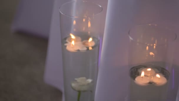 Kerzen am Hochzeitstisch, zwei dekorative Kerzen werden auf dem Tisch entzündet. — Stockvideo