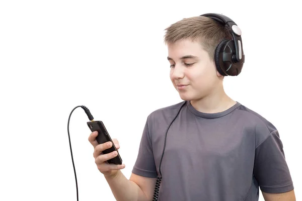 Η φωτογραφία απεικονίζει ένα αγόρι φορώντας ακουστικά και τηλέφωνο — Φωτογραφία Αρχείου
