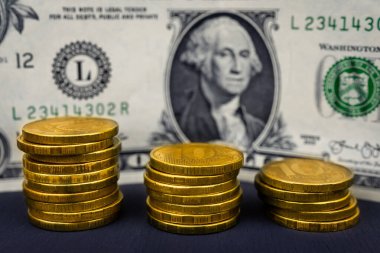 10 rublelik madeni paralar ve siyah arka plandaki dolar. Rublonun düşüşü konsepti.