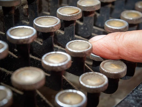 Closeup dedo digitando máquina de escrever vintage coberto com poeira — Fotografia de Stock