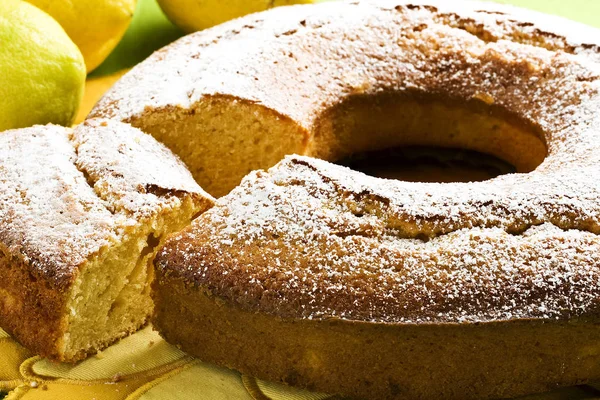 Angel food cake sliced with silver fork and lemons — Stock Photo, Image