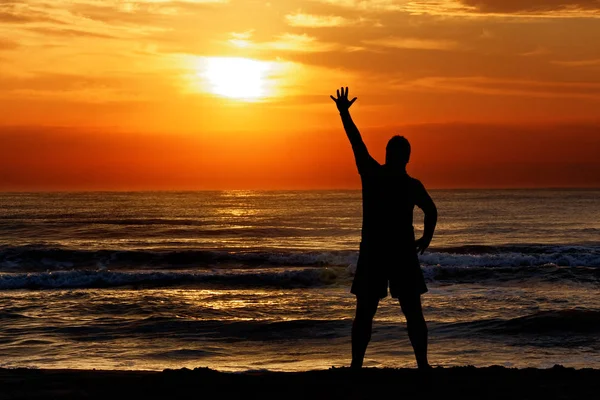 太陽の日没海を振って男のシルエット — ストック写真