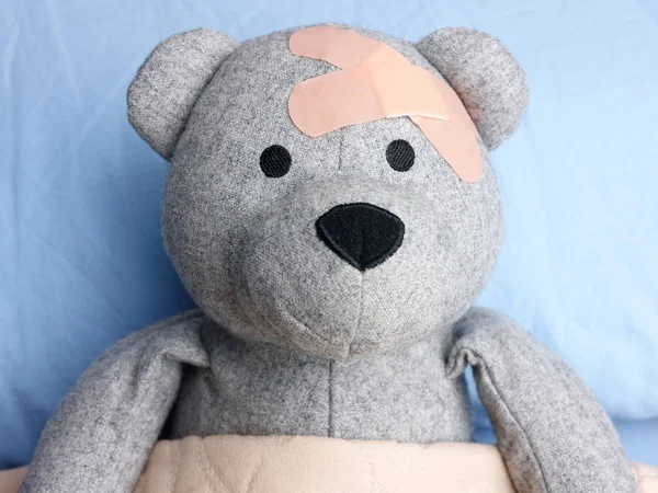Verletzter Teddybär gipst Kopfbett — Stockfoto