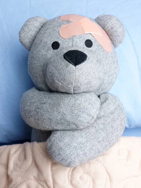 Verletzter Teddybär verputzt Bett — Stockfoto