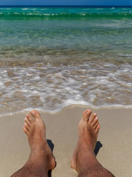 Pés na praia desfrutando do relaxamento e da vista incrível do mar paradisíaco — Fotografia de Stock