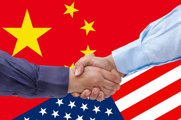 Des hommes d'affaires serrant la main sur les drapeaux américains ou américains et chinois ont fusionné concept de relations politiques et économiques — Photo