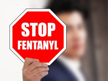 man holding STOP FENTANYL road sign