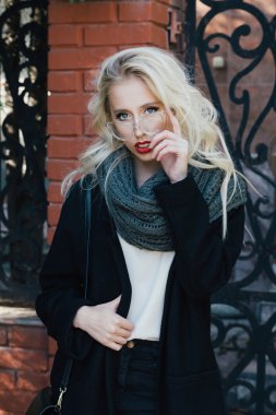 Çit yakınındaki sarışın kıvırcık saçlı kadın