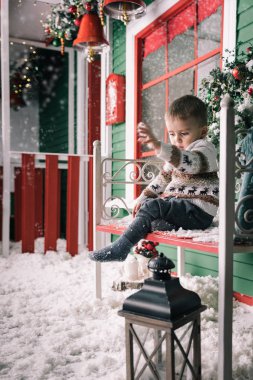 Küçük çocuk bankta oturan