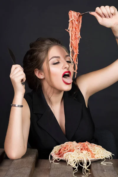 Mujer comiendo pasta en mesa de madera — Foto de Stock