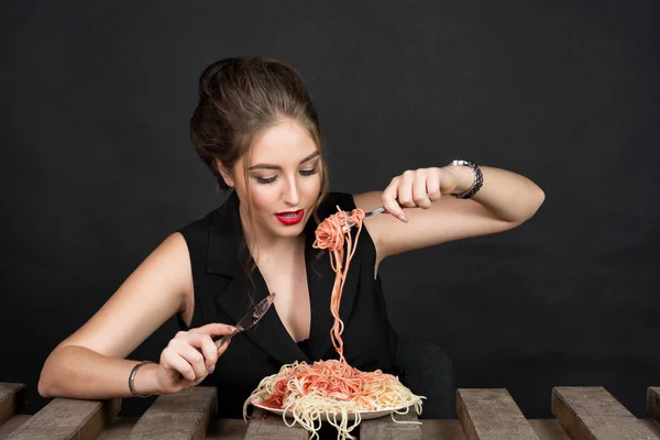 Donna che mangia pasta al tavolo di legno — Foto Stock