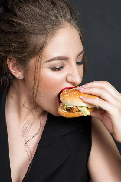 Slim bella donna mangiare un hamburger — Foto Stock