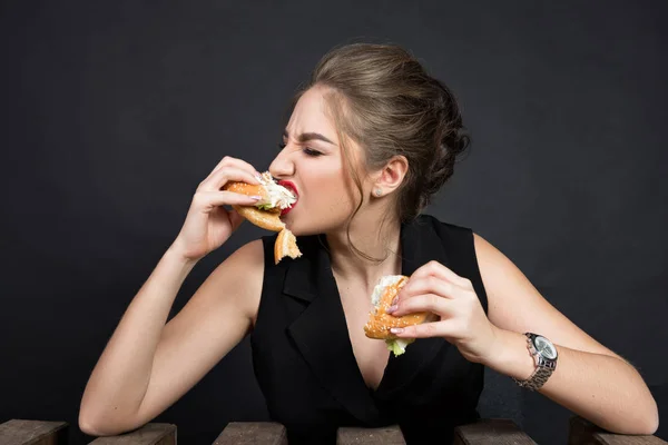 Slim bella donna mangiare un hamburger — Foto Stock