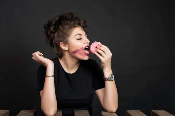 Стройная красивая женщина ест пончик — стоковое фото
