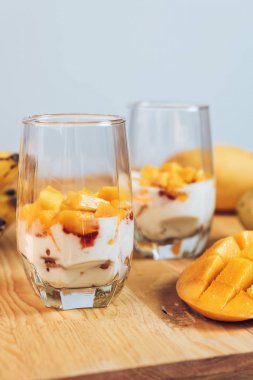 Glasses of yoghurt with mango and strawberry clipart