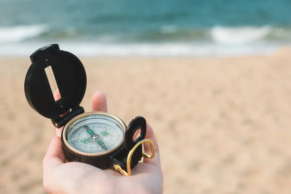 Mano femenina con brújula sobre fondo oceánico —  Fotos de Stock