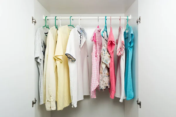 Clothes hanging on rail in white wardrobe. — Stock Photo, Image