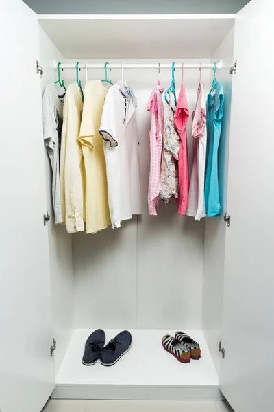 Одежда висит на поручне в белом шкафу . — стоковое фото