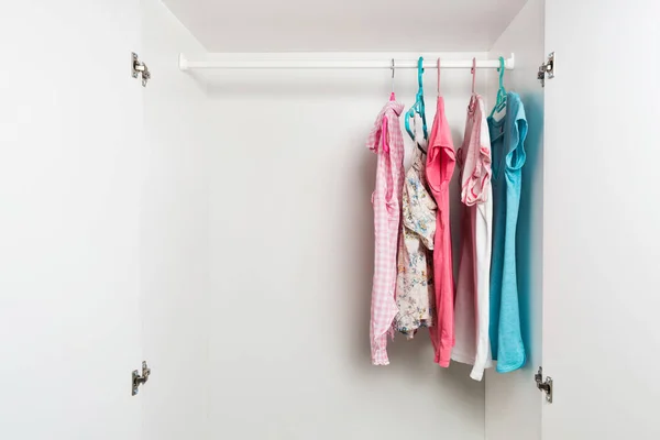 Clothes hanging on rail in white wardrobe. — Stock Photo, Image