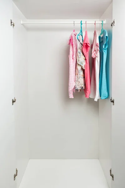 Clothes hanging on rail in white wardrobe. — Stock Photo, Image