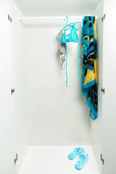 Costume da bagno appeso su rotaia in armadio bianco . — Foto Stock