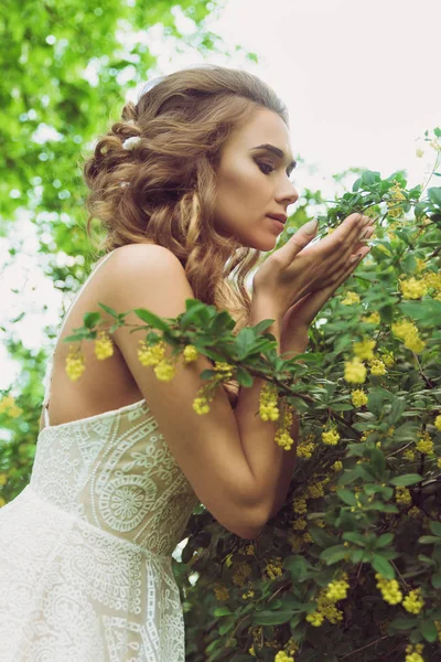 Mujer bonita disfrutando del olor flores — Foto de Stock