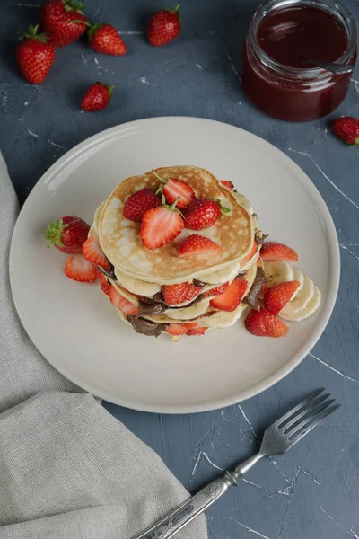 Delicious pancakes on grey table with fruits. — Stock Photo, Image