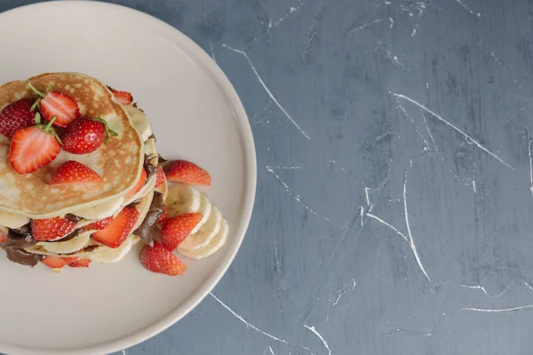 Deliciosas panquecas na mesa cinza com frutas . — Fotografia de Stock