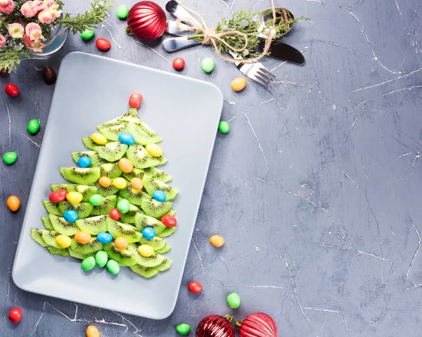 Kiwi fruit Christmas tree dessert on plate. — Stock Photo, Image