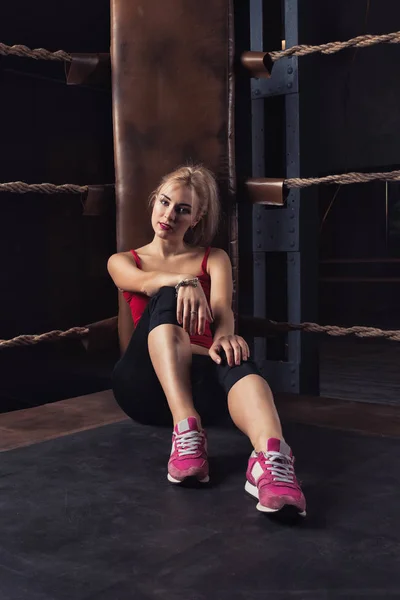 Sexy blonde woman sitting on boxing ring. — Stock Photo, Image