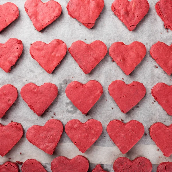 Red velvet heart cookies on baker paper.